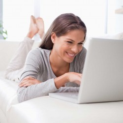 happy woman on computer on couch